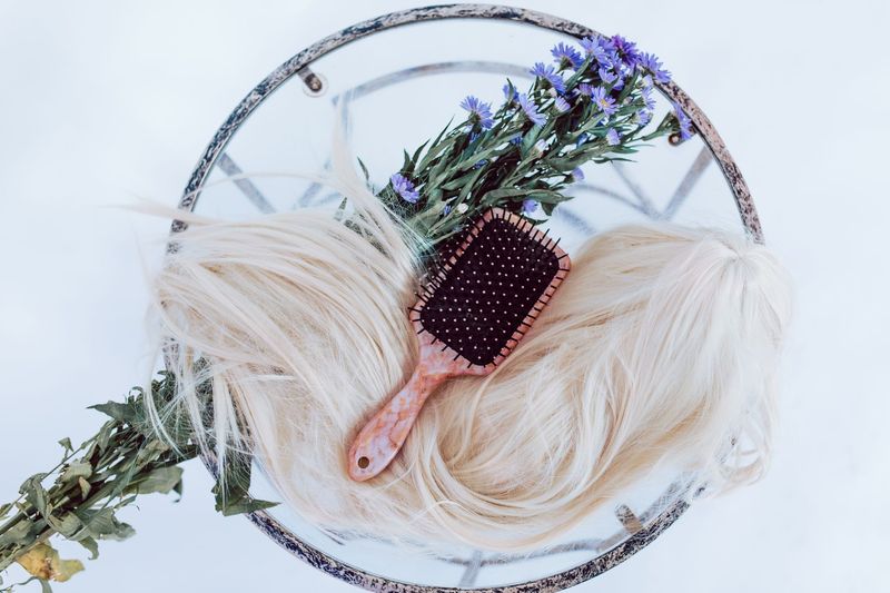 Black and white hair brush styled with a white and green floral wreath